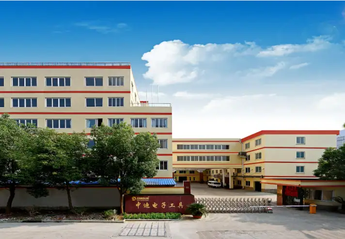University campus building with multiple floors, surrounded by green trees and a clear blue sky, showcasing modern architecture and a welcoming academic environment.