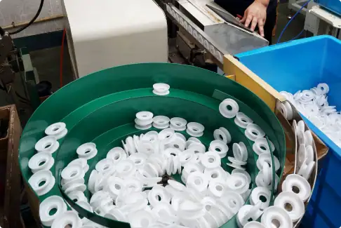 Plastic washers spinning in a green circular conveyor.