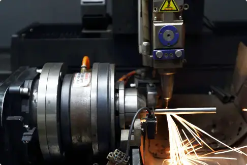 Laser cutting machine performing precise metal fabrication with sparks and bright light.