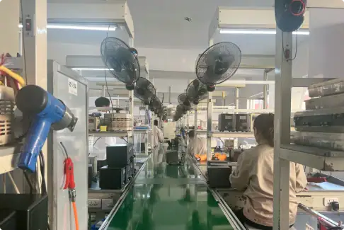 Modern electronics manufacturing assembly line with workers and equipment in a clean, organized factory setting.