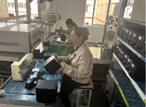 Electronics technicians assembling circuit boards and testing electronic components in a factory setting.