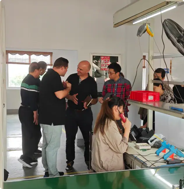 An image of a diverse group of people working together in an electronics workshop, engaging in hands-on activities with tools and equipment, fostering teamwork and technical skills.