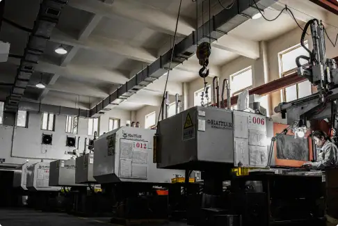 An image of advanced industrial machinery used in high-precision manufacturing processes, featuring large CNC machines with safety labels and control panels in a well-lit factory setting.